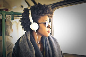 beautiful black women with headphones looking out window